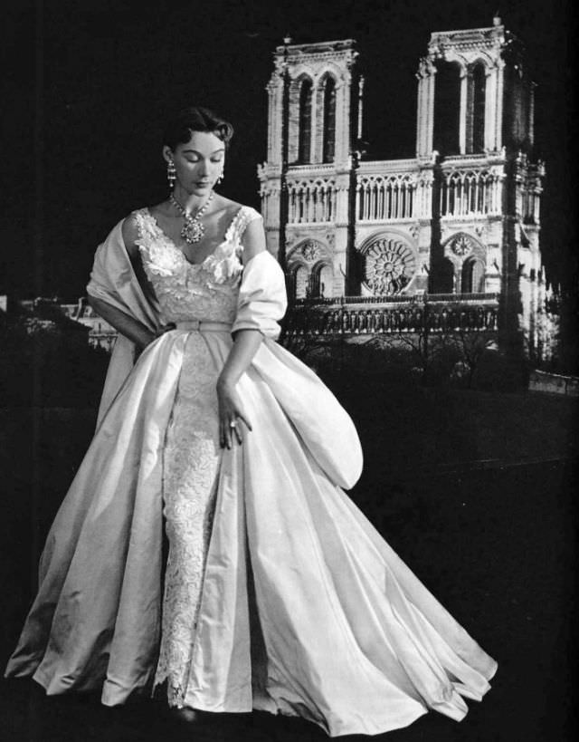 #33 Sophie Malgat in white Marescot lace sheath enveloped in skirt and stole of white faille by Lucille Manguin, 1951