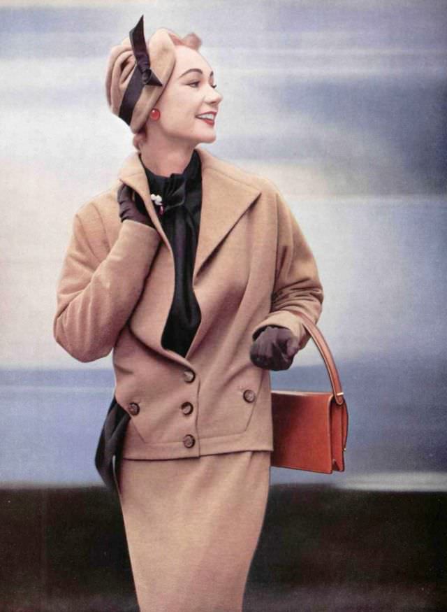 #14 Sophie Malgat in elegant jersey suit, jacket has neck and wide lapels that open on silk surah blouse by Lucille Manguin, hat is by Jean Barthet, leather handbag by Innovation, 1952