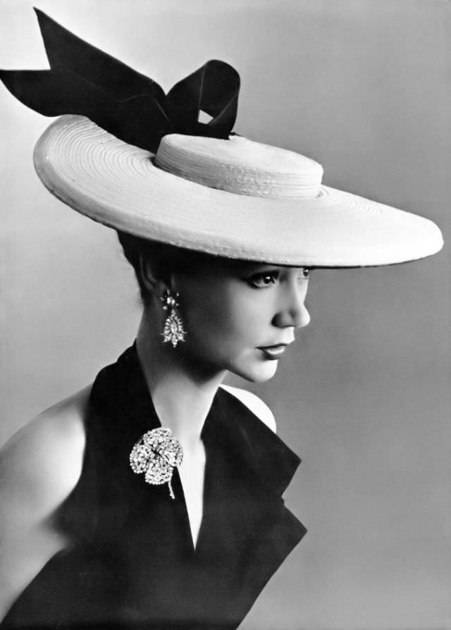 #9 Sophie Malgat in large straw boater adorned with black satin bow by Legroux Soeurs, brooch and earrings by Roger Scémama, 1952
