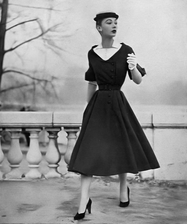 #10 Sophie Malgat is wearing a thin blue wool dress with deep décolletage filled with white linen, has linen undersleeves, by Jean Patou, Harper’s Bazaar, April 1952