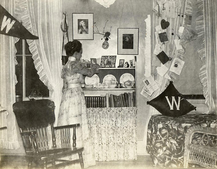 #35 This woman’s dorm room from 1898 isn’t much different from modern day dorms: Pennants, books, and a chair for studying.
