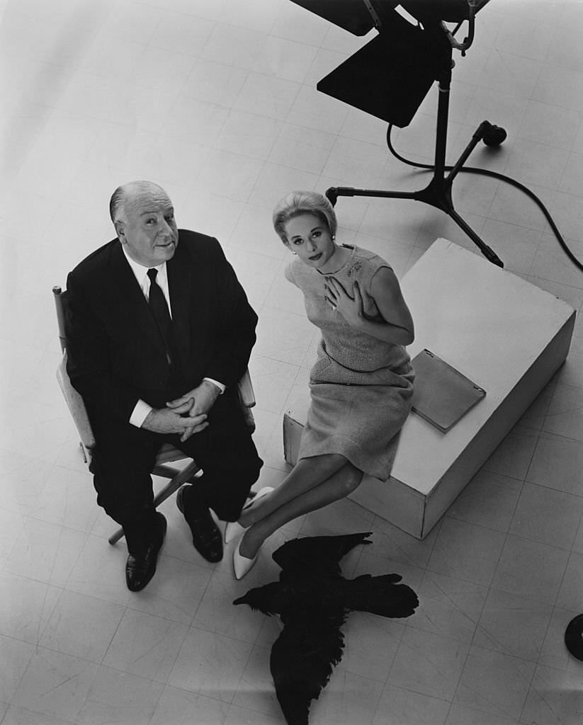 Alfred Hitchcock and leading lady Tippi Hedren pose with a stuffed raven on the set of the film ‘The Birds, 1963.