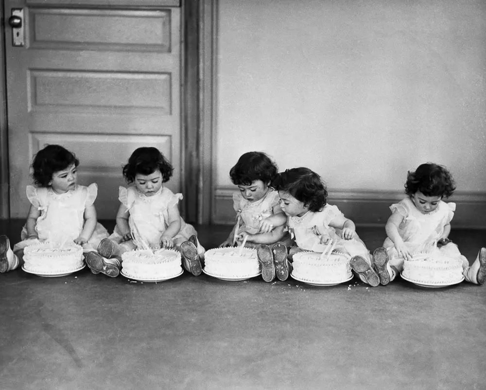 The quintuplets celebrate their second birthdays with individual cakes, 1936.