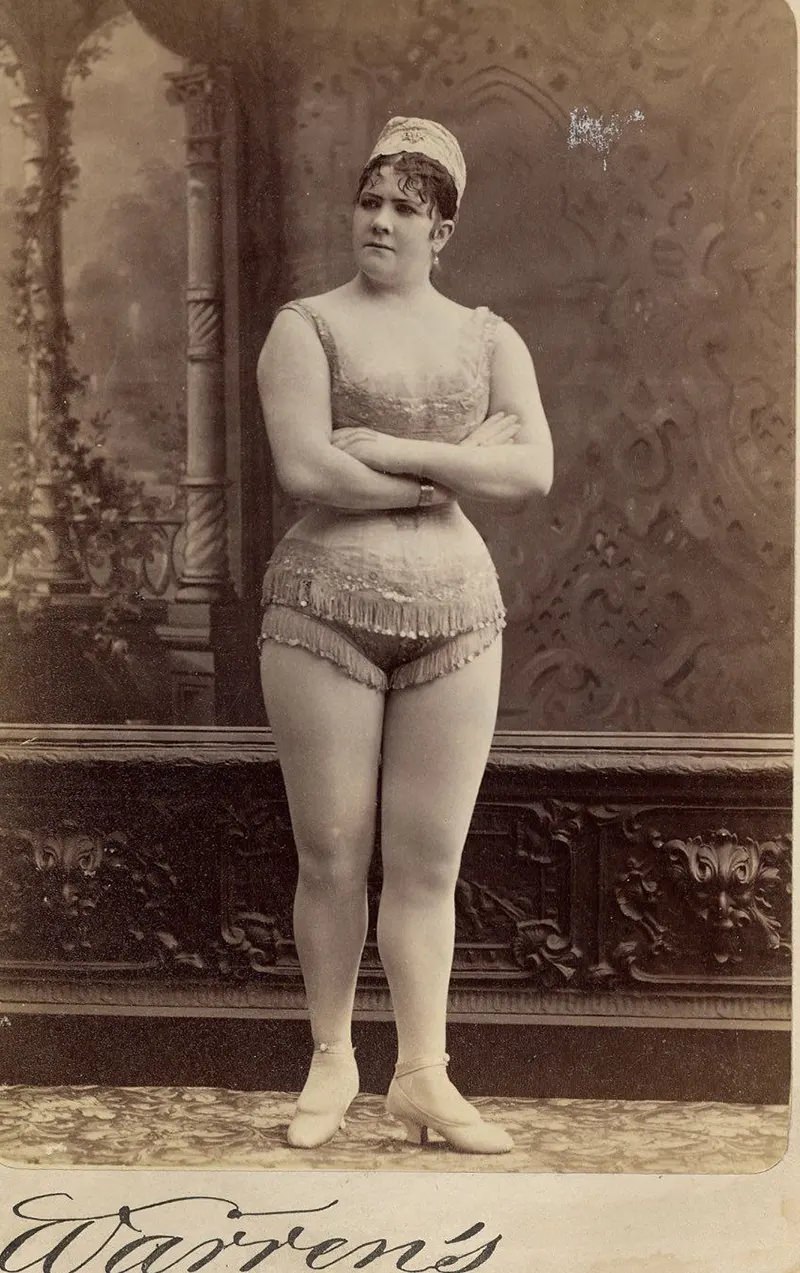 #12 Viola Clifton facing front in a sleeveless, short, fringed top and short, fringed trunks.