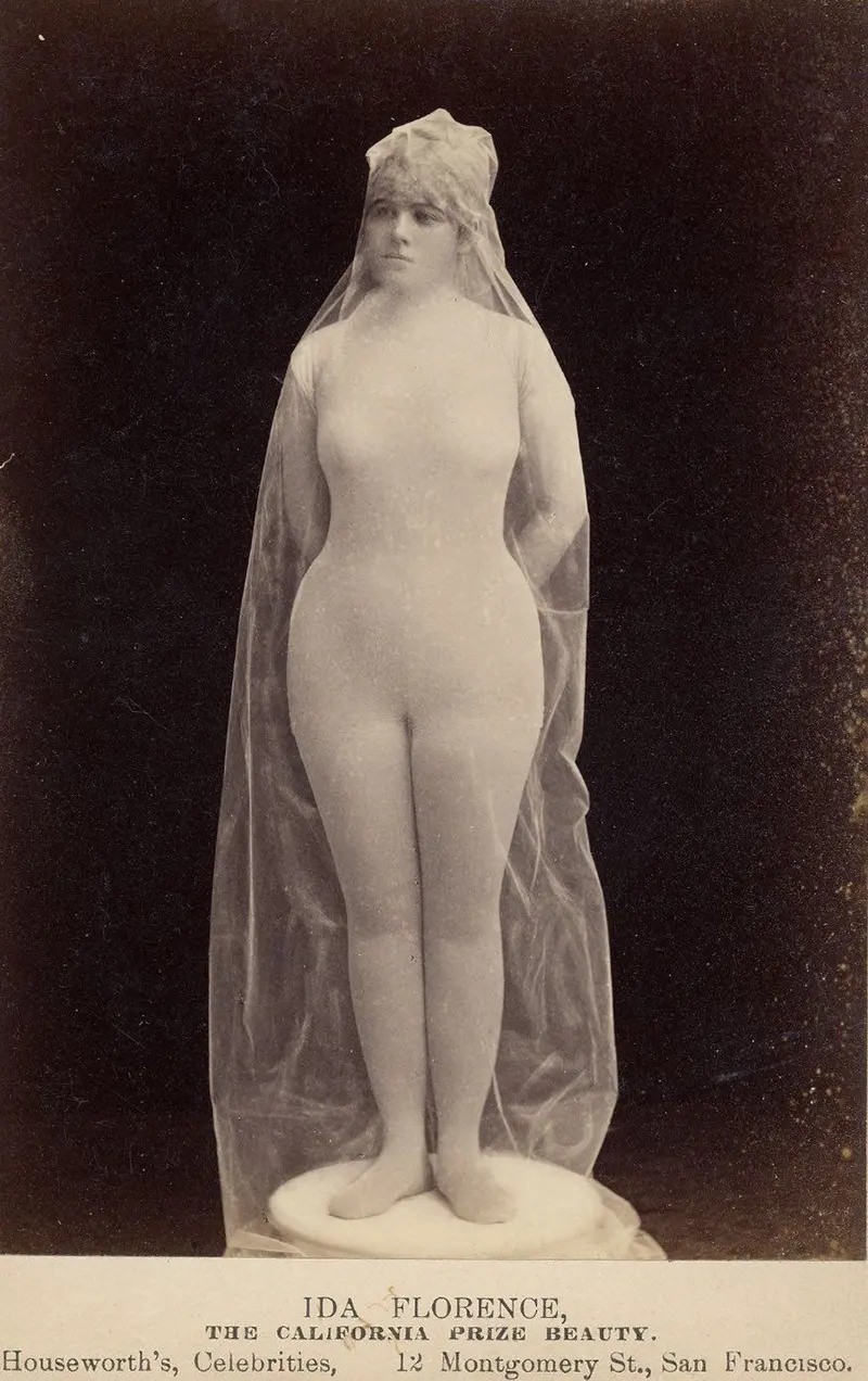 #23 Ida Florence, “The California Prize Beauty,” in body stocking covered with transparent fabric, posed as statue.