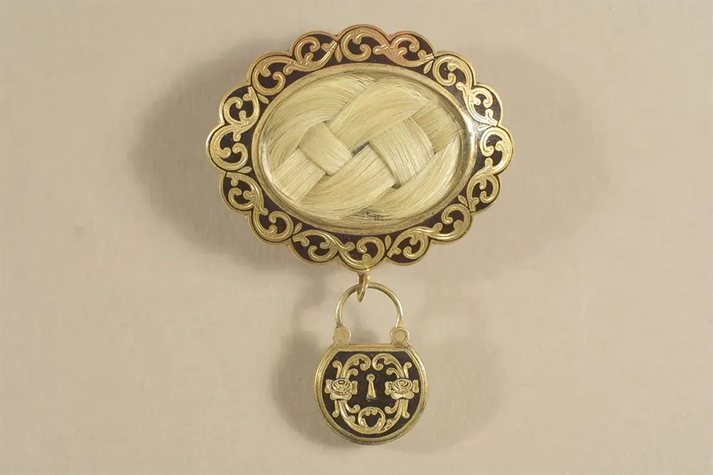 #1 A gold and black mourning brooch with a plait of the deceased’s hair under glass.