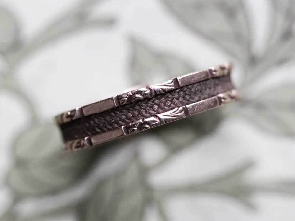 #21 A miniature urn dangles from this gold mourning brooch.