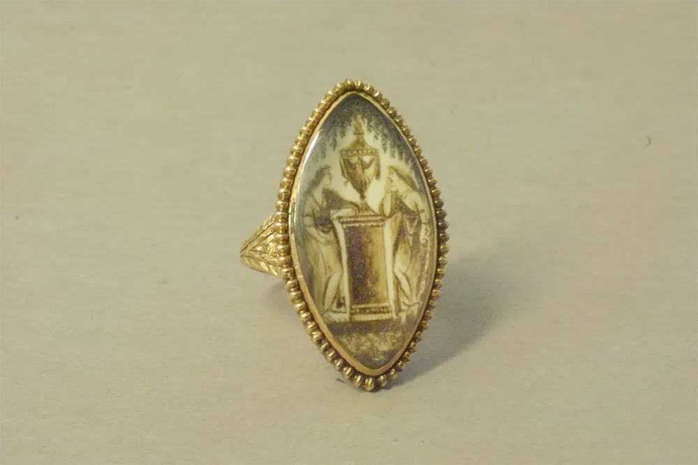 #9 A gold mourning ring featuring a painting on ivory of two women with a funerary urn.