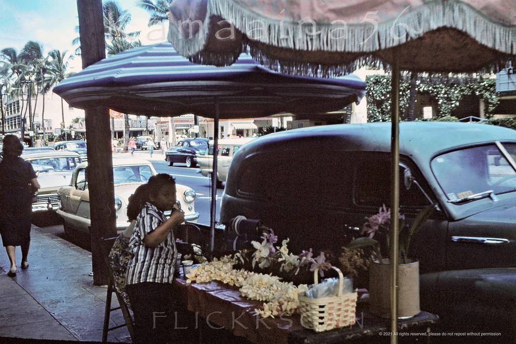 #74 Lei seller on the sidewalk of Waikiki’s Kalakaua Avenue in front of the Royal Hawaiian Hotel, 1959