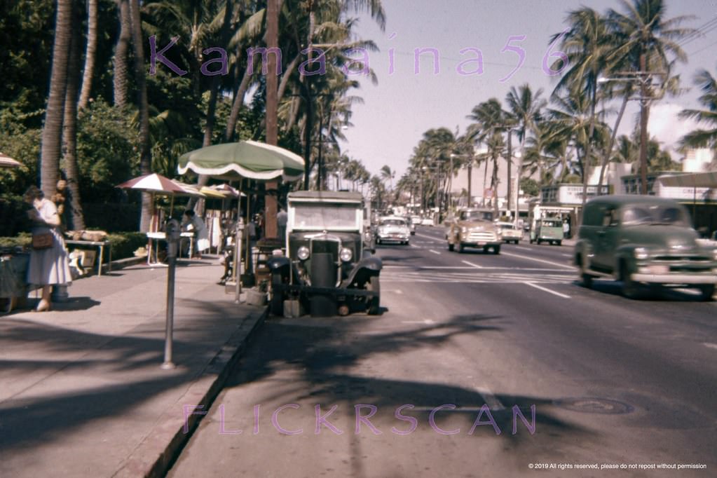 #75 Waikiki’s Kalakaua Avenue at the sidewalk sellers in front of the grounds of the Royal Hawaiian Hotel, 1958