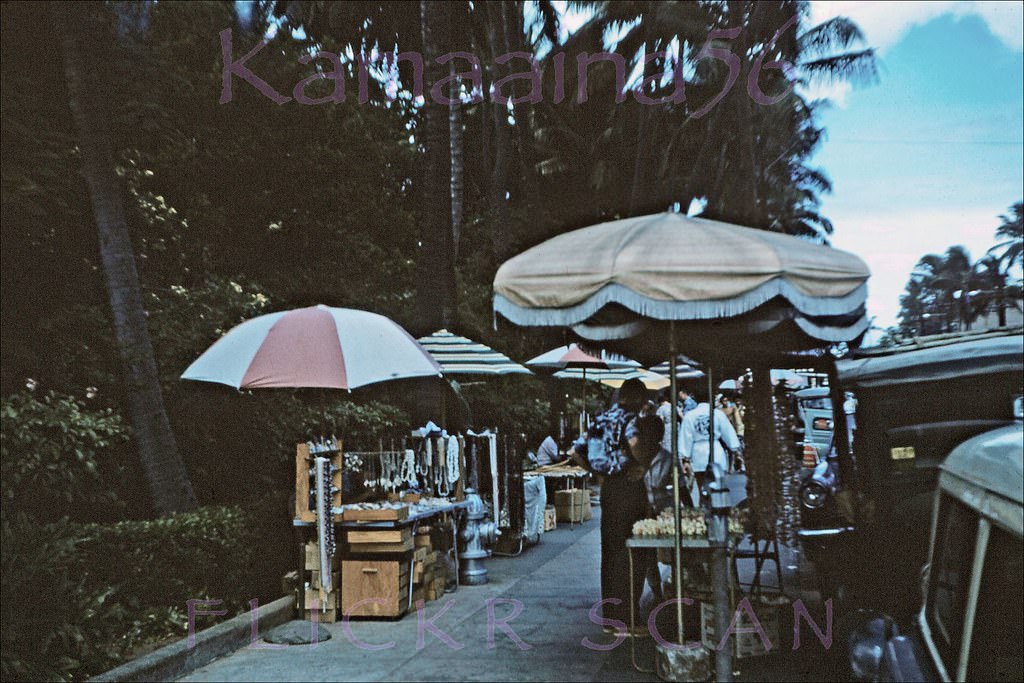 #76 Vendors on the sidewalk of Waikiki’s Kalakaua Avenue in front of the Royal Hawaiian Hotel, 1959.