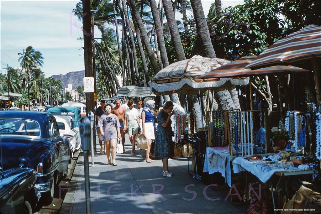 #42 Hawaiiana and souvenir vendors on the sidewalk of Waikiki’s Kalakaua Avenue fronting the Royal Hawaiian Hotel, 1961