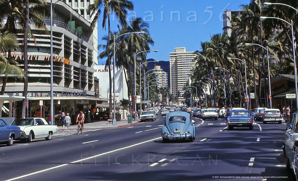 #64 Two-way traffic and on-street parking along Waikiki’s busy Kalakaua Avenue at Royal Hawaiian Avenue, 1966
