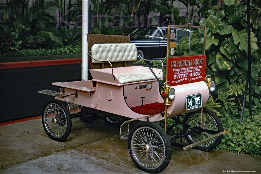 #17 Oldsmobile Model R Curved Dash Runabout on the sidewalk in front of Waikiki’s Moana Hotel Advertising Na Kupuna (the elders) Night Wednesdays in the Banyan Court, 1962