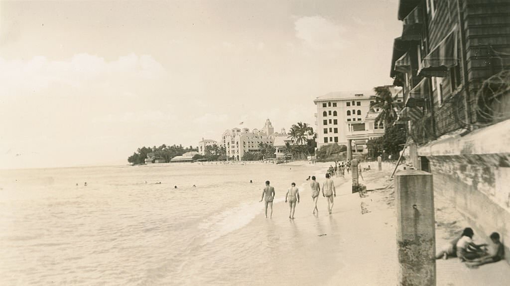 #61 Men walk on sand at Waikiki, 1940s
