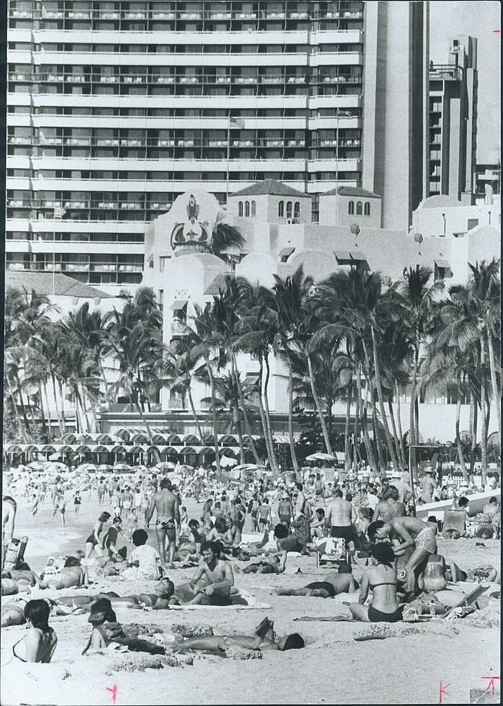 #11 Wall-to-wall people pack the beach at Waikiki every day sun shines, 1970s