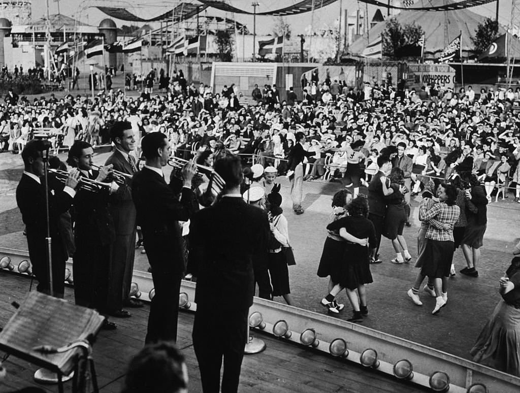 #128 People pair up and dance while Ozzie Nelson and his band perform on stage at the amusement area of the 1939 New York World’s Fair in Flushing Meadow Park.