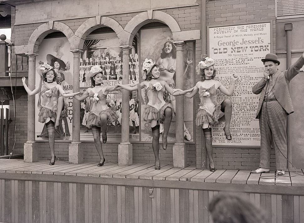 #143 A barker performs with show girls at George Jessel’s “old New York” cabaret, at the New York World’s Fair, 1939