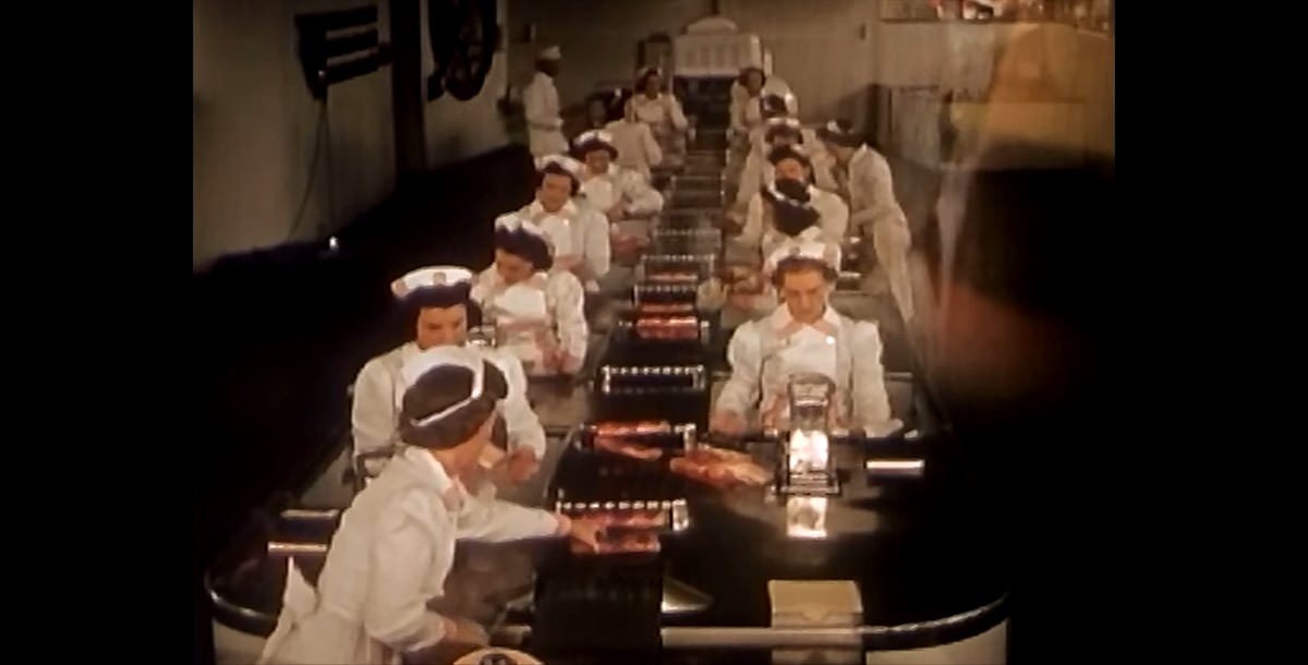 #25 Workers in an exhibit use modern techniques to package bacon for Swift Premium Meats.