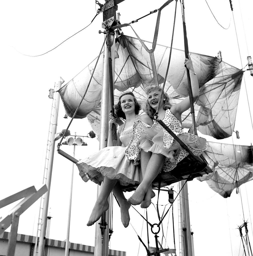 #88 Models from the CBS gameshow, “The Big Payoff,” Pat Conway and Connie Mavis ride The Parachute Jump, originally built for the 1939 World’s Fair, at Steeplechase Park.