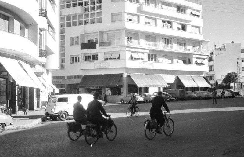 #110 People bicycling past modern buildings in Rabat, 1960s