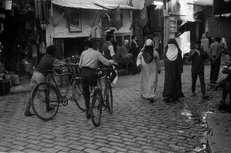 #78 Boys walking bicycles through souk, 1960s