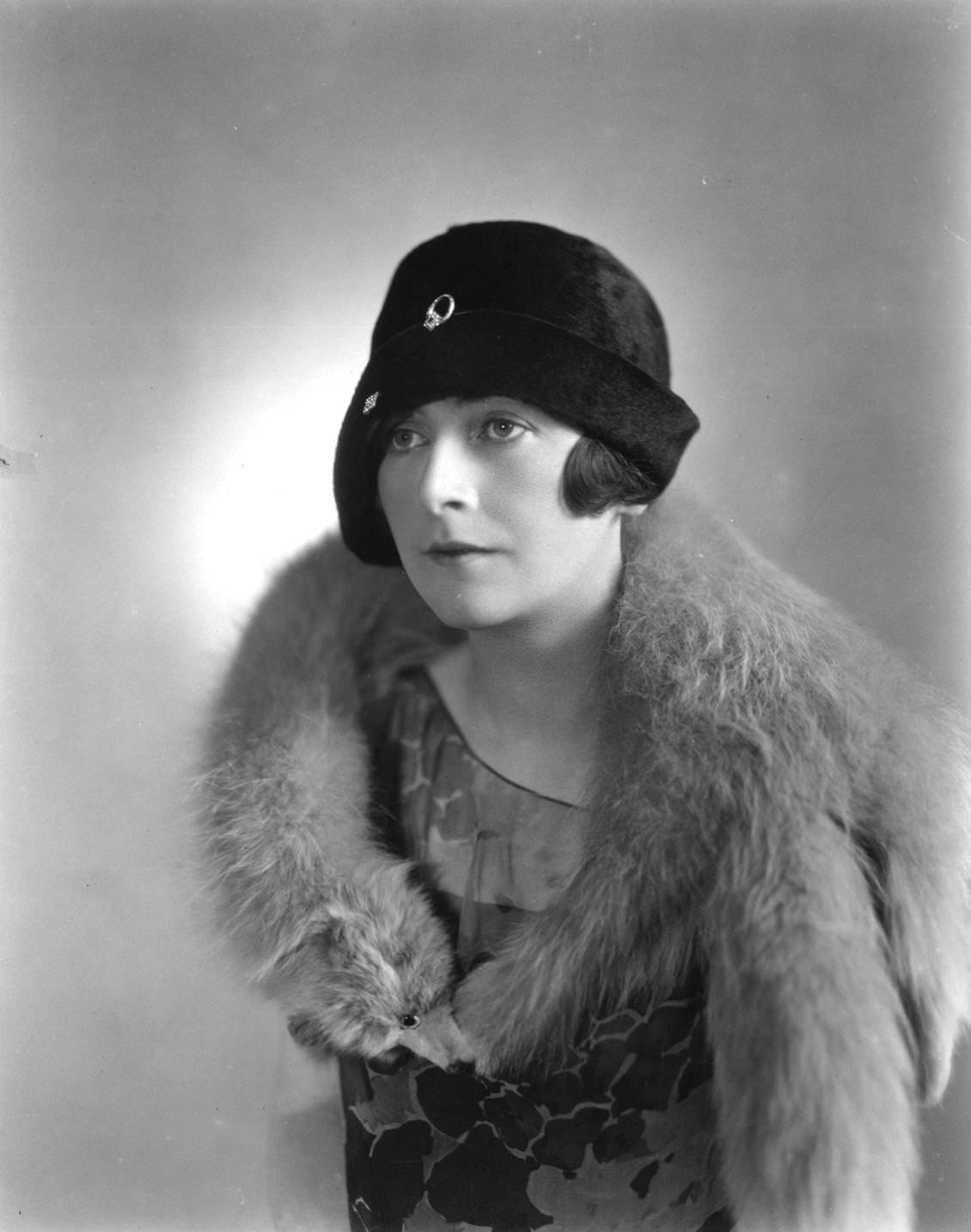 #105 A woman wearing a cloche hat designed by Cyris Slymore and a fur collar, 1925