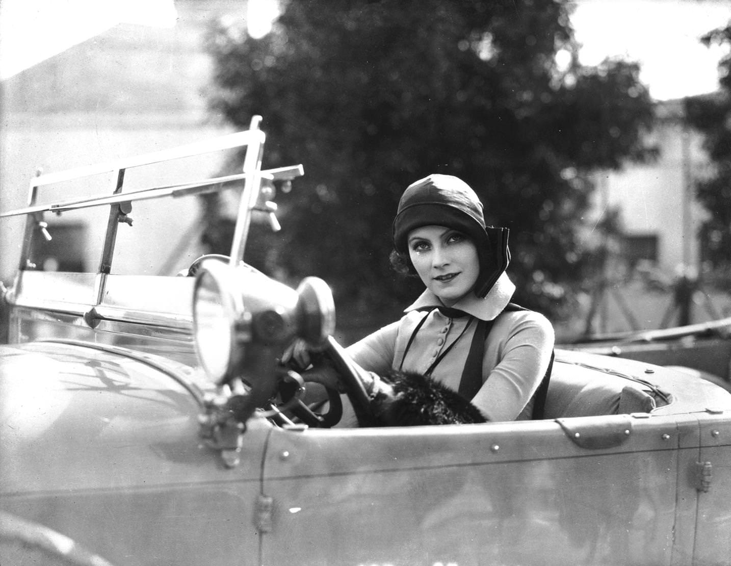 #158 Swedish film star Greta Garbo in cloche hat at the wheel of an automobile, 1925