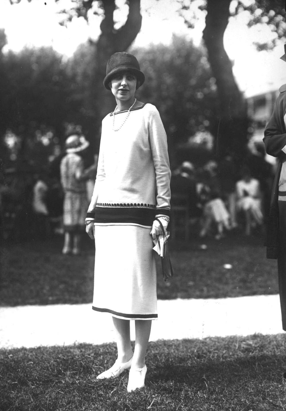 #161 A woman wearing a dress made in Deauville at a garden party, 1925