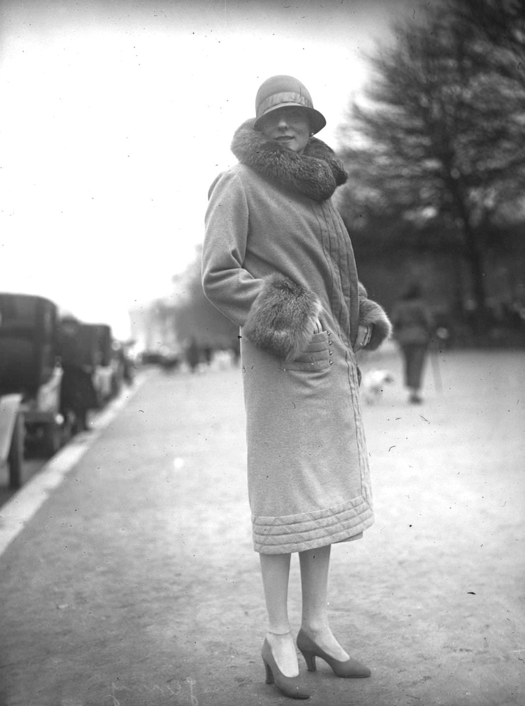 #172 A model wearing a coat with a large fur collar and cuffs and a close fitting cloche hat, 1925