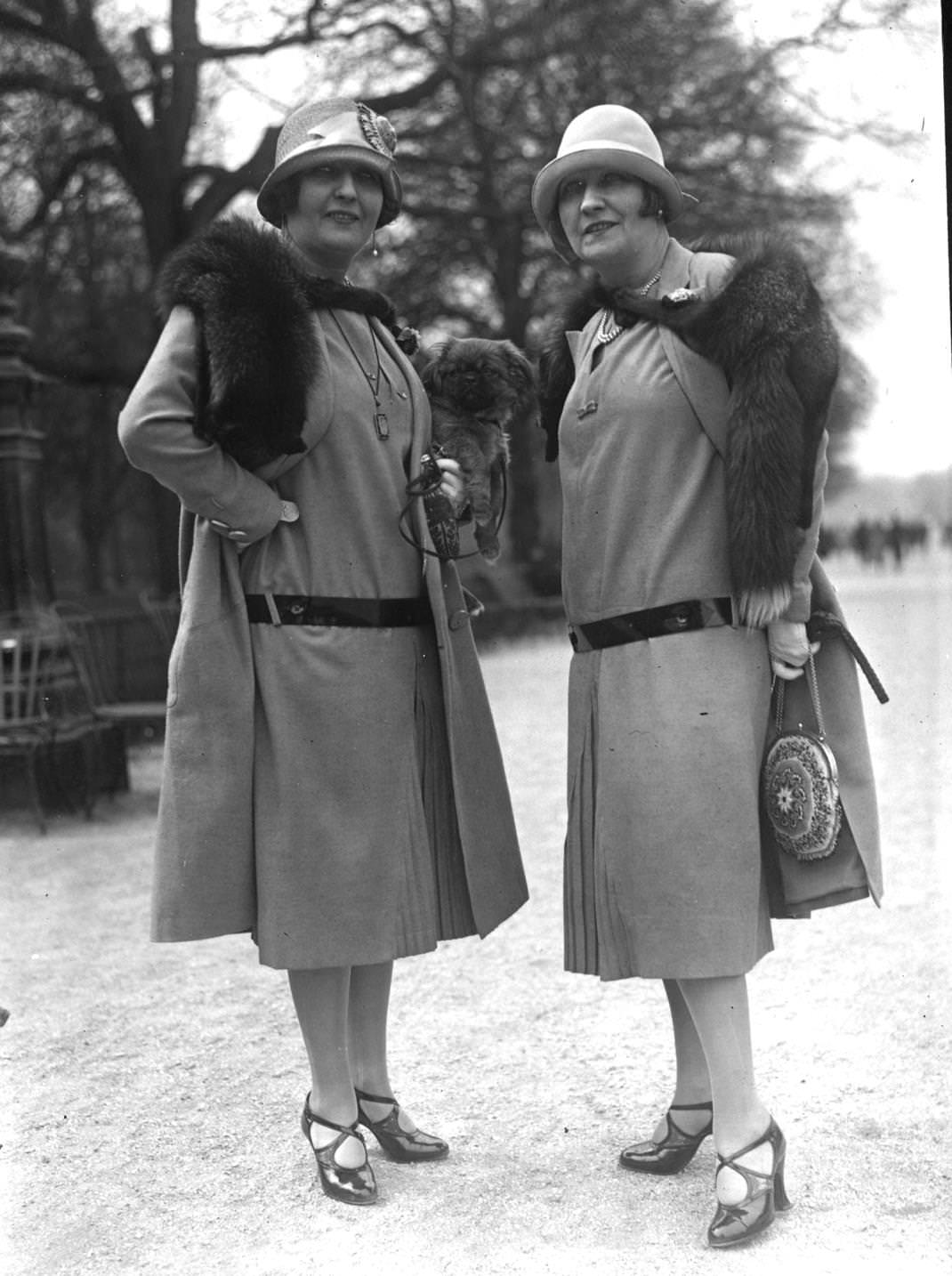 #178 Spring Outfits with long waisted dresses with front pleats worn with matching loose coats, cloche hats and fox furs, 1925