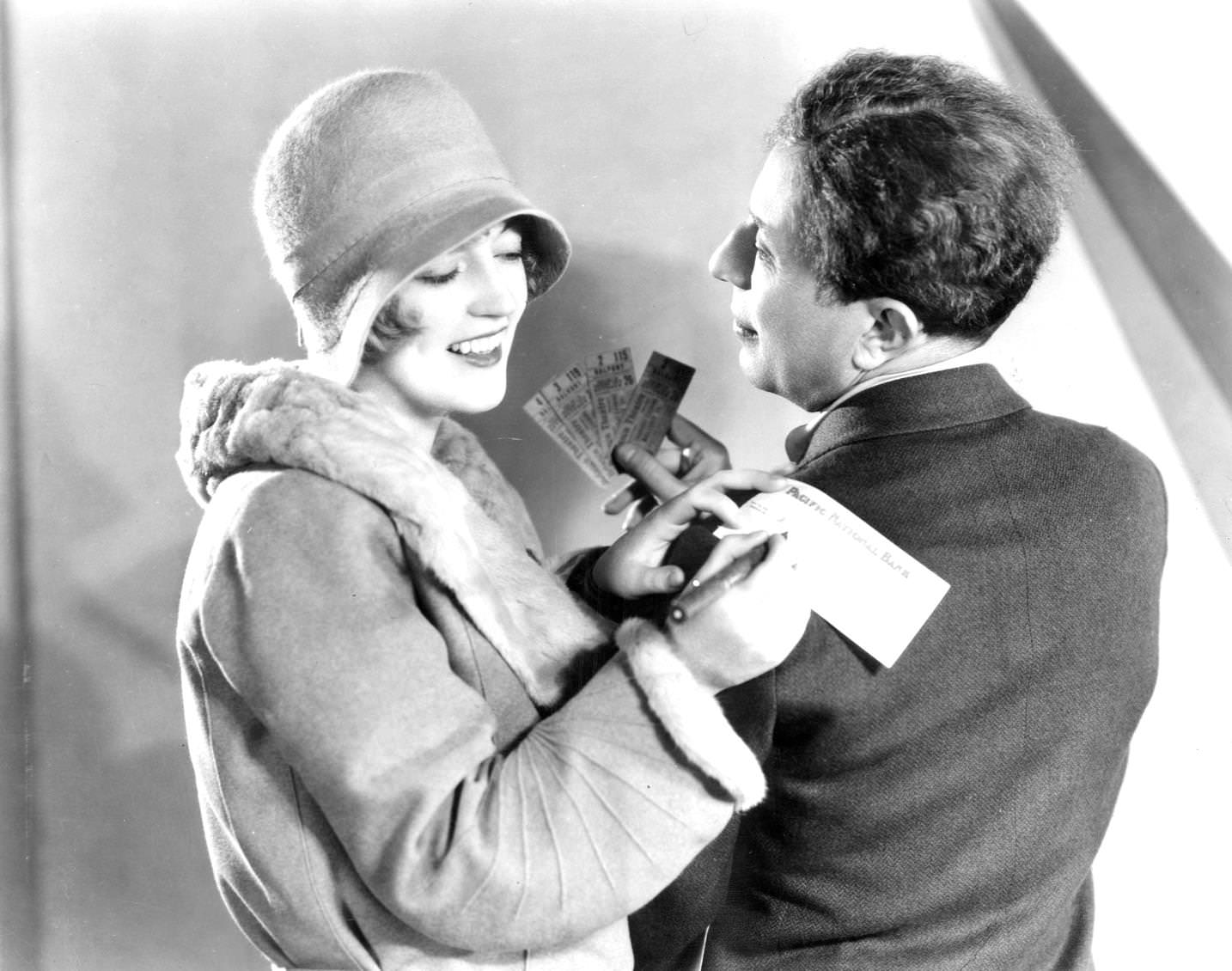 #31 A smiling Marion Davies igns a cheque on Sid Grauman’s shoulder for tickets to ‘The Broadway Melody’, 1920