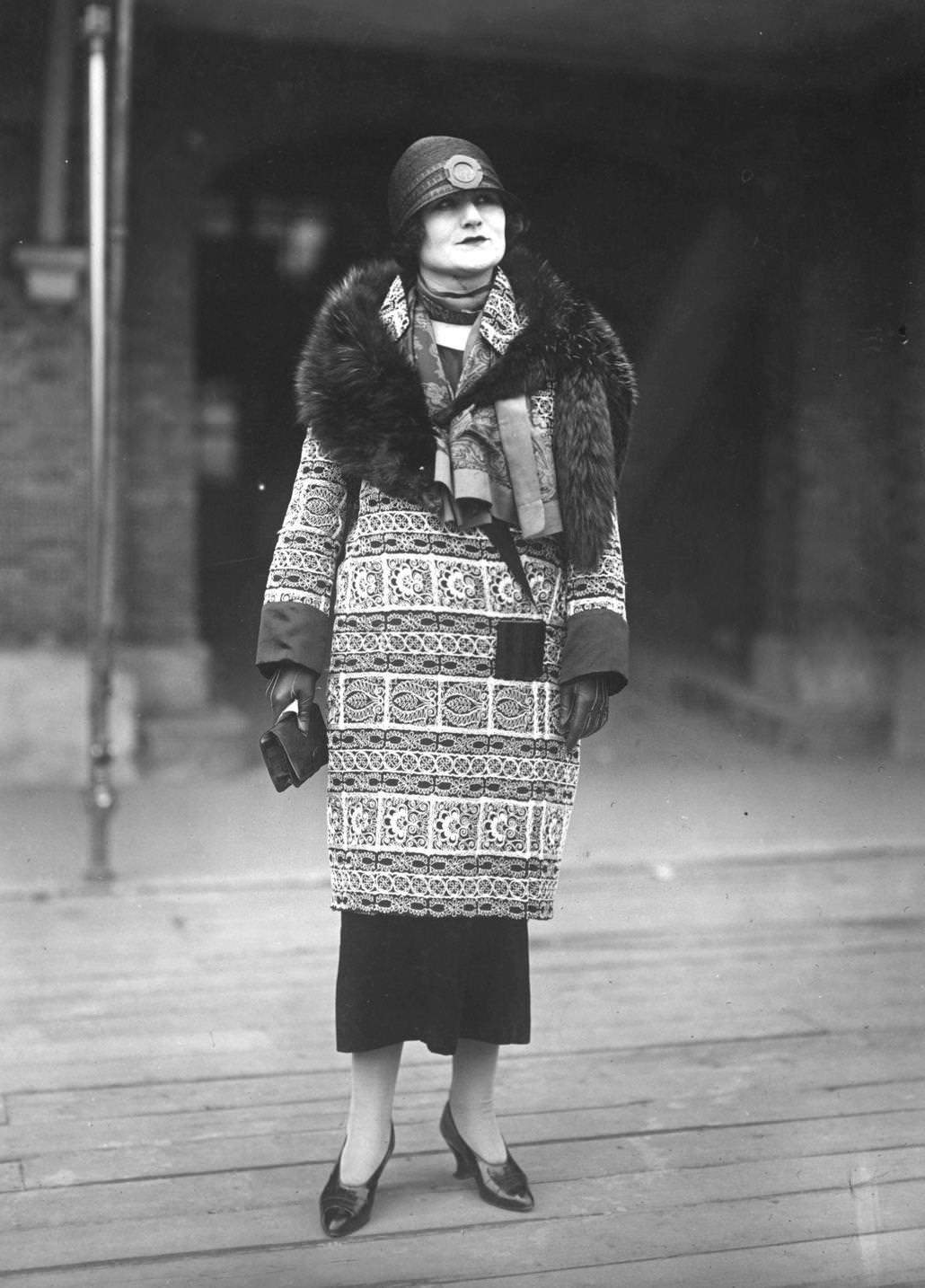#46 A model wearing a printed coat with a fur stole and a fashionable cloche hat, designed by Drecoll, 1924