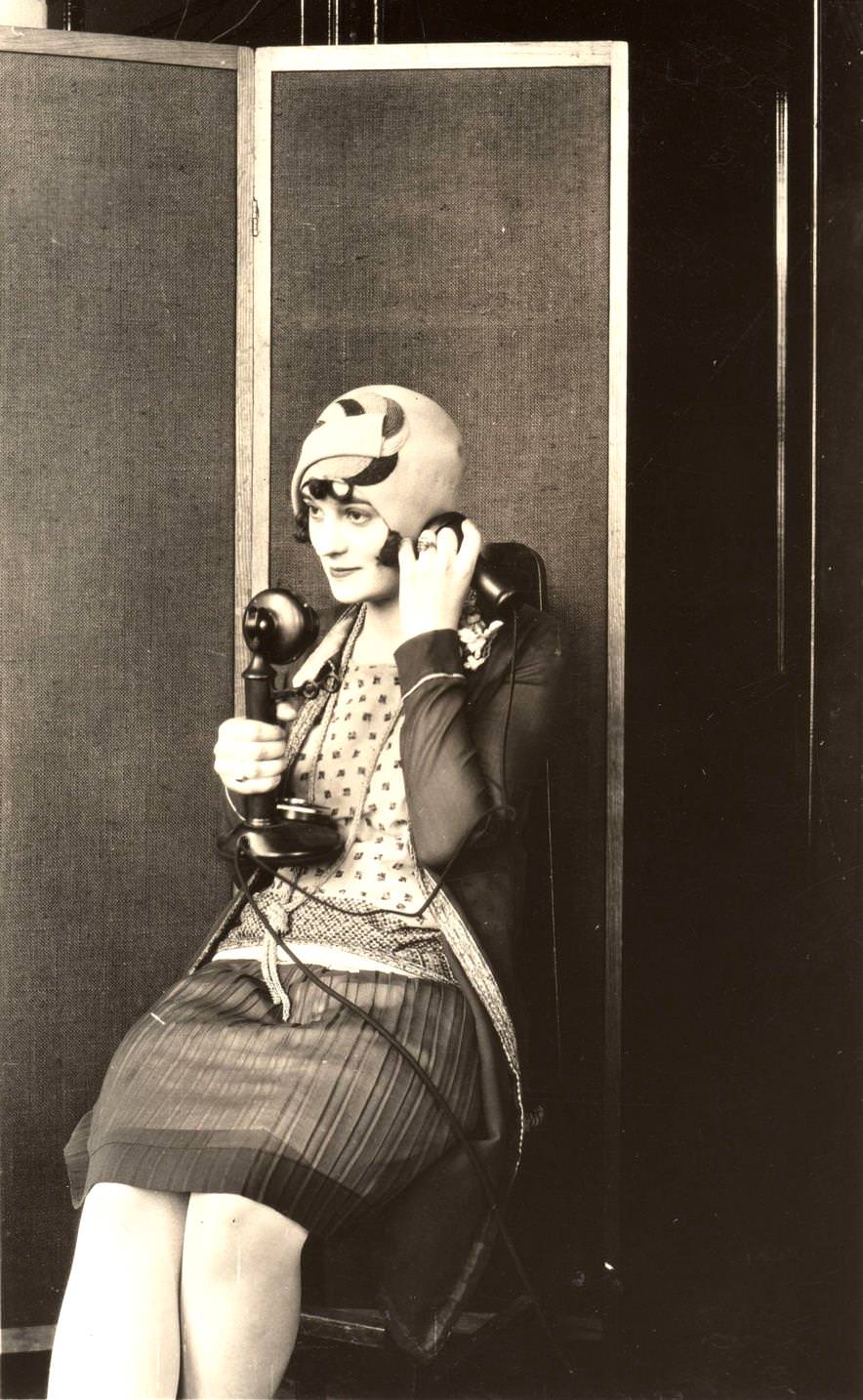 #1 A woman wearing a felt cloche hat and using the telephone, 1922.