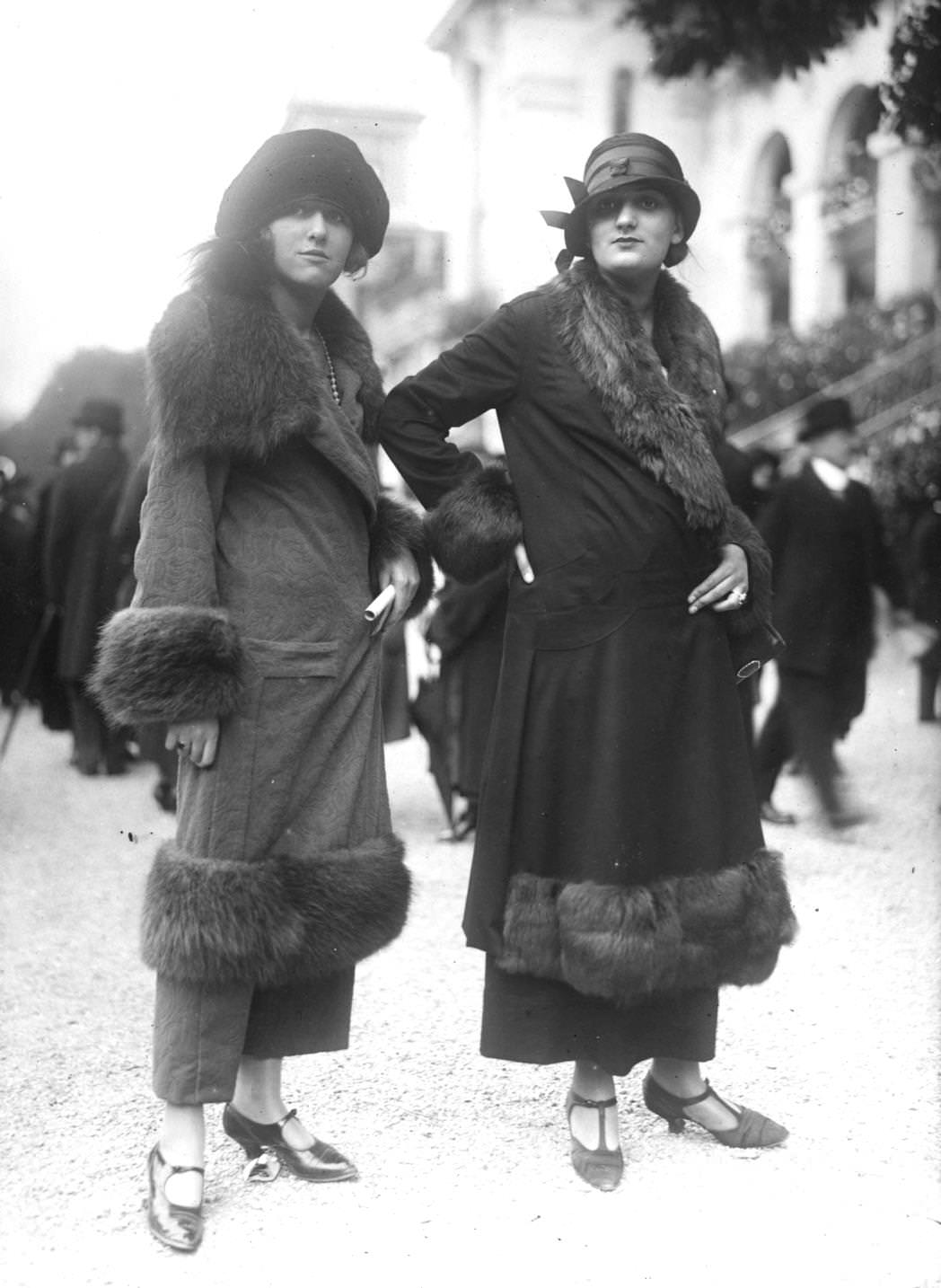 #4 Two women in fur-trimmed wrap over coats, ankle length skirts, and cloche hats, 1923