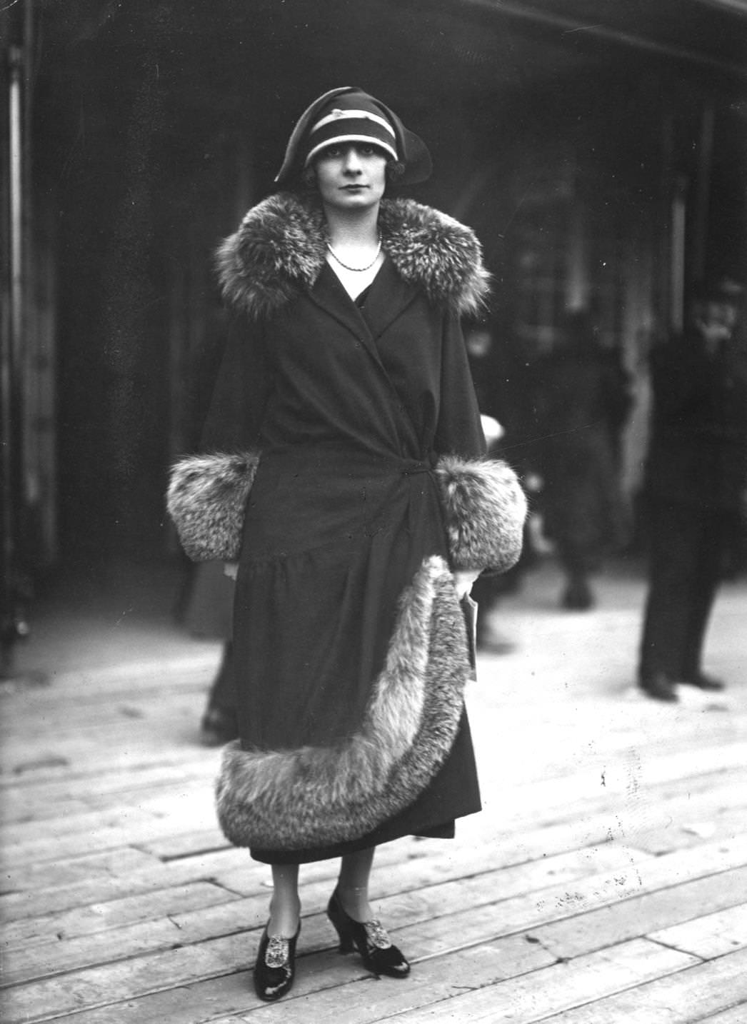 #80 The model wears a fur trimmed coat which buttons at the side and cloche hat, 1923