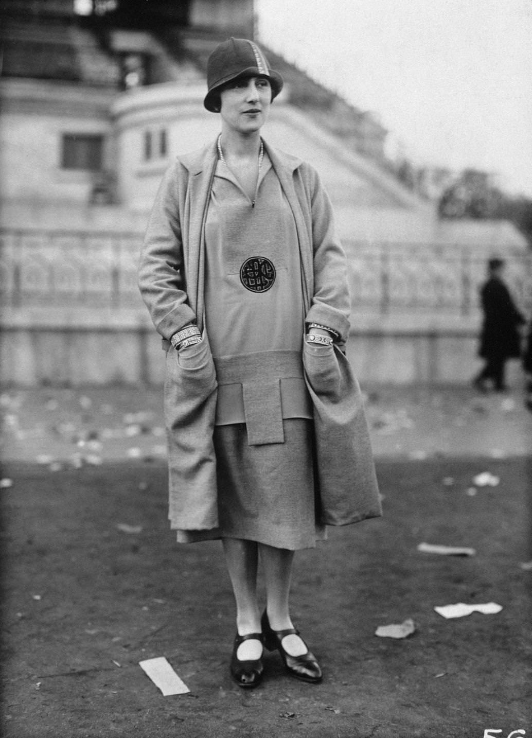 #96 Fashion model wearing a drop-waisted dress with matching jacket, cloche hat, and Mary Jane shoes, 1925