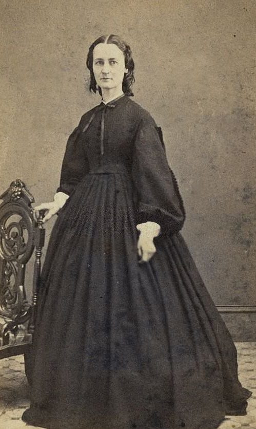 #10 A woman wearing the extremely full-skirted fashion which relied on hoops and crinolines under the dress, 1860