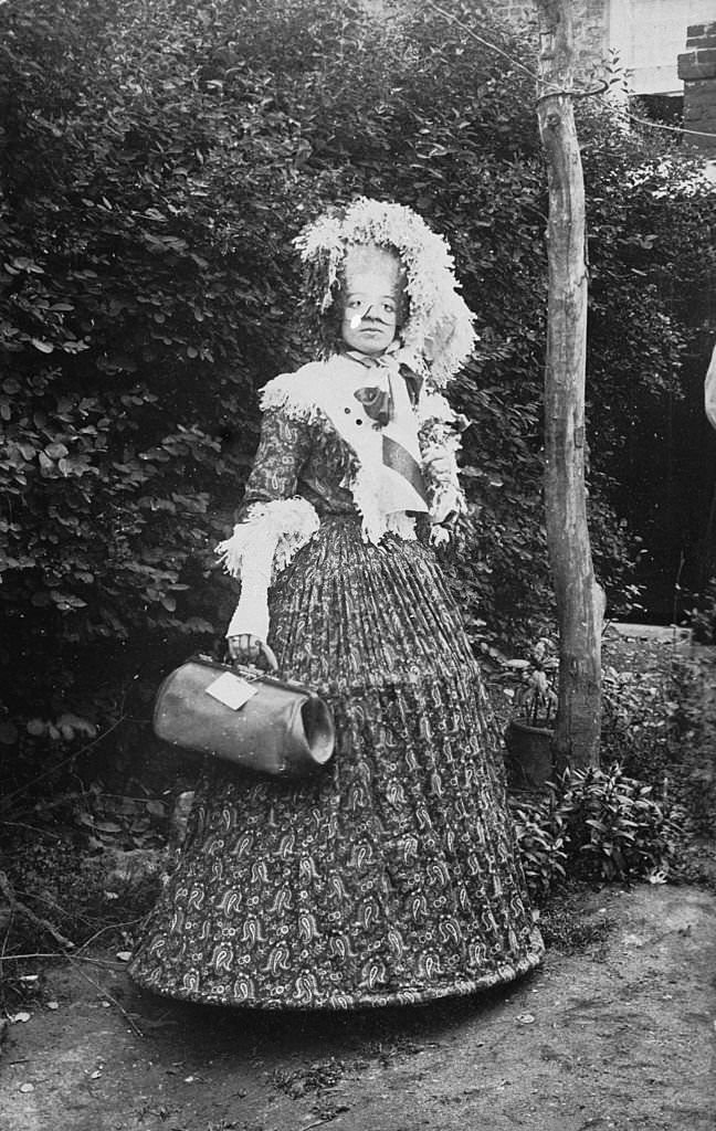 #20 A victorian woman wearing a hooped dress with an eye mask and fingerless gloves, 1860