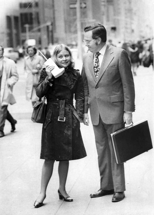 #2 Jeanne Bauer walks with a DynaTAC on 6th Avenue in New York, accompanied by John Mitchell, the Motorola engineer behind the phone, 1973.