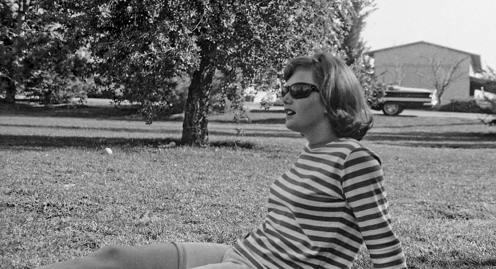 #122 Coed watching the picnic baseball game, 1966