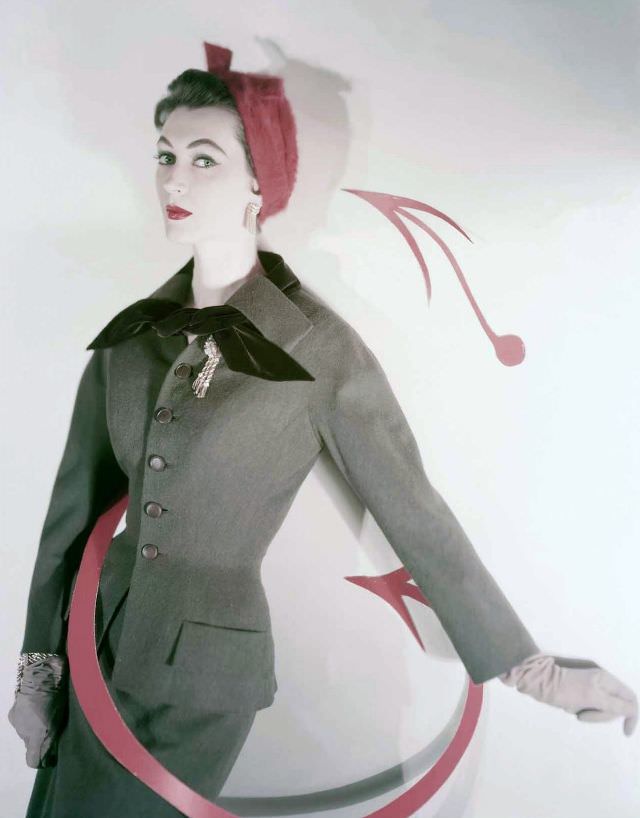 #24 Dovima wearing a taupe wool and velvet suit by Ben Zuckerman with a red hat by Jacques Fath, photo by Horst P. Horst used for cover of Vogue, 1953