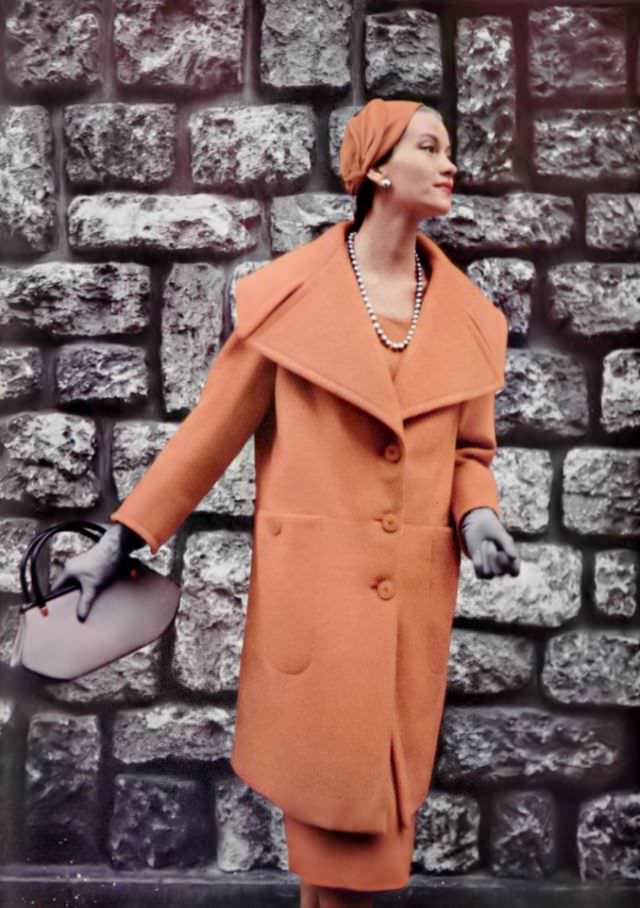 #30 Anne Campion in orange wool coat in the new 3/4 length with deep indented collar and large pockets by Jacques Fath, 1954