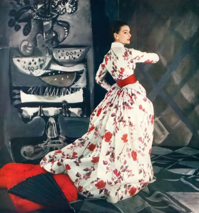 #31 Anne Gunning in beautiful satin-striped silk organdy gown in floral print of reds and dusky leaves worn under its Victorian jacket by Jacques Fath, Vogue, April 15, 1954