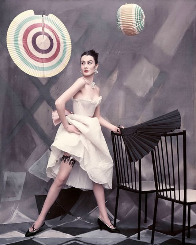 #38 Patricia Prunonosa is wearing white back-laced bodice brassiere, lace petticoat, and black lace topped stockings from the Jacques Fath collection, Vogue, 1954