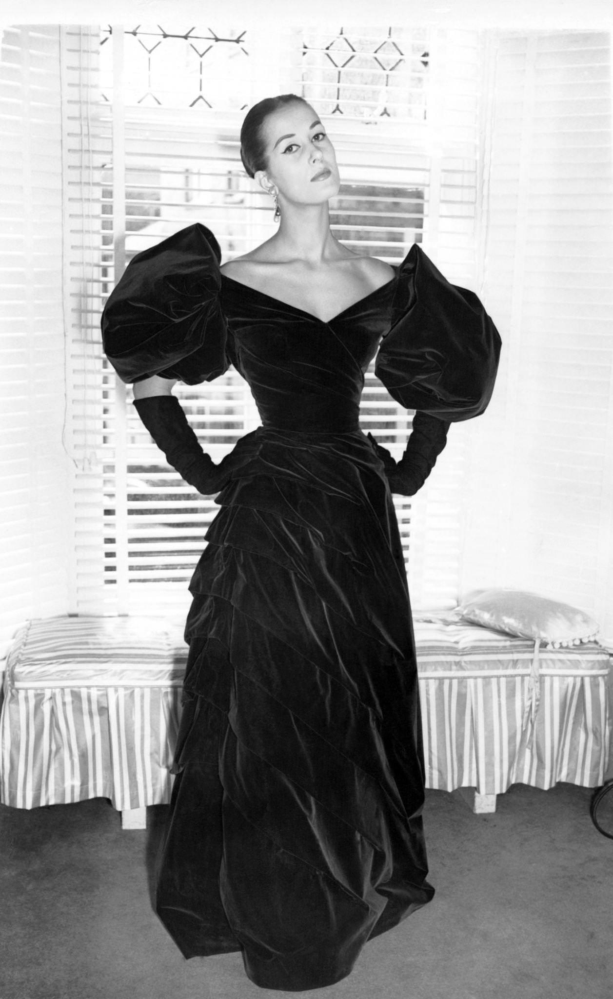 #63 Green velvet evening dress with large puff sleeves and draped skirt. Created by Jacques Fath. London on September 26, 1955.