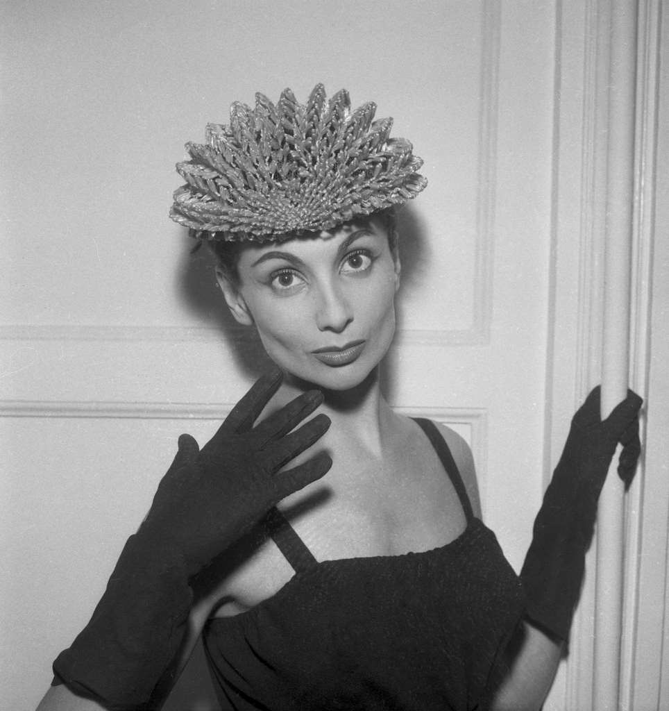 #65 Model presenting a model by Jacques Fath, a spring hat and gloves, in Paris, France on January 28, 1957.