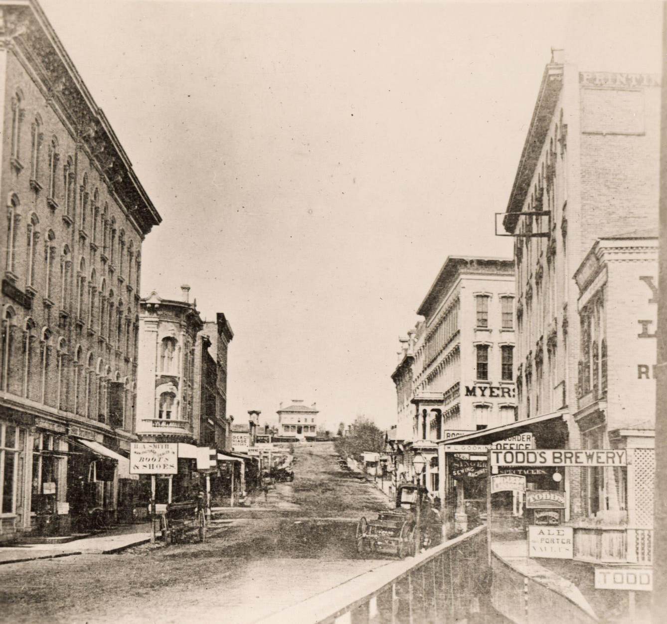 #27 Milwaukee Street looking east in Janesville, Janesville, Wisconsin, 1870. The Myers House is located at the top of the hill.
