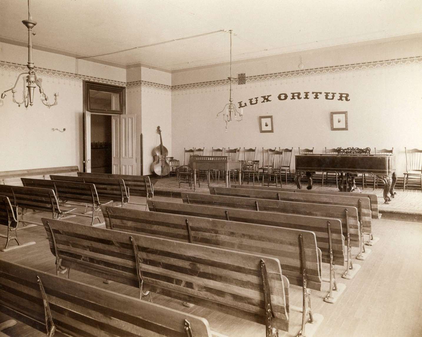 #19 Music recital room at the State School for the Blind with seven rows of seating, a piano and cello, Janesville, Wisconsin, 1893.