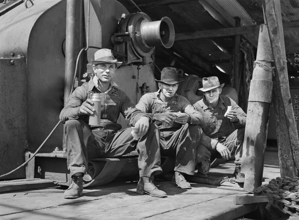#167 C.L. Saxton, Driller, J.G. Betz, Cathead Man and L.C. Westerman, eating Lunch around Oil Well, Continental Oil Company, Moundridge, Kansas, September 1941